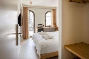 a bedroom with a large white bed with white sheets at Casa Dalida Boutique Hotel in Datca