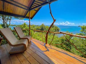 two chairs on a deck with a view of the ocean at Araya Dive Resort Togean in Bomba