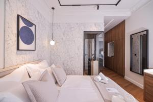 a bedroom with a large white bed and a bathroom at Estium Luxury Rooms in Zadar