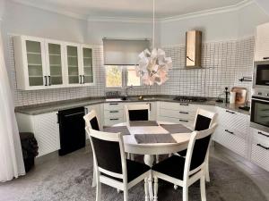a white kitchen with a table and chairs in it at 4 bed room Villa Alsancak Girne in Lageia