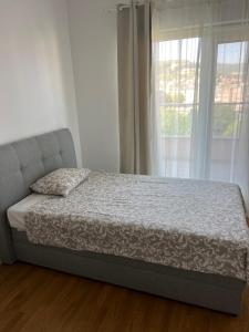 ein Bett in einem Schlafzimmer mit einem Fenster in der Unterkunft Cozy central apartment in Čapljina
