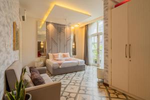 a bedroom with a bed and a couch at ELIVAAS Signature Casa Ritzy Mediterranean 5 BHK Hideaway with Pool near Popular Beaches in Calangute +100 photos