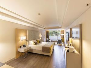 una camera d'albergo con un letto e una grande finestra di Palladio Hotel Buenos Aires - MGallery Collection a Buenos Aires