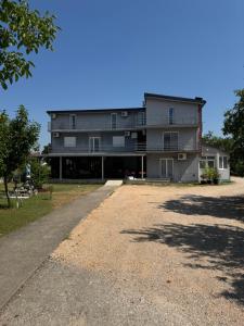 a large building with a gravel driveway in front of it at Apartments Lucijan Međugorje in Međugorje