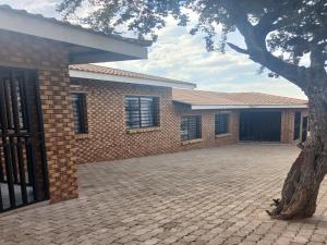 a brick house with a tree in front of it at Carissa Street Self-catering Units in Burgersfort