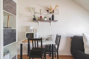 a kitchen and dining room with a table and chairs at Studio zen JD54#1 in Reims