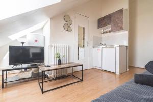 a living room with a television and a coffee table at Studio zen JD54#1 in Reims