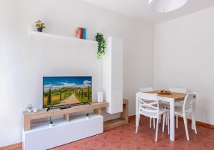 Una sala de estar con un televisor y una mesa. en Landi 2 - Near the center, free public parking, en Pisa