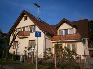 a white house with a brown roof at Apartments Centrum in Liptovský Mikuláš