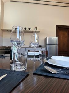 a wooden table with two wine glasses on top of it at La Castellina di Monticchio - Appartamento Centrale con Parcheggio in Monticchio +29 photos