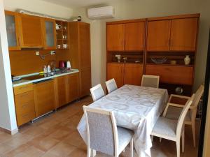 a kitchen with a table and chairs in a kitchen at Panorama apartman-50m od mora in Krašići