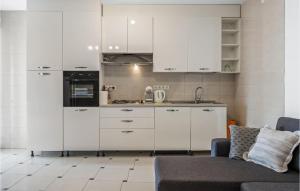 una cucina con armadi bianchi e un divano di Awesome Home In Grebastica With Wifi a Grebaštica