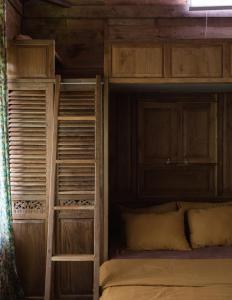 a bedroom with two bunk beds with wooden walls at Natural, warm, tropical villa in Tanah Lot
