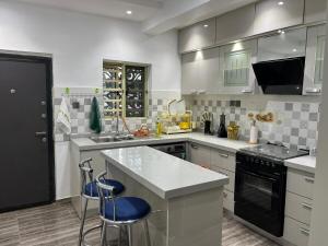 a kitchen with white cabinets and blue stools in it at 2 bedroom home Ikeja in Ikeja