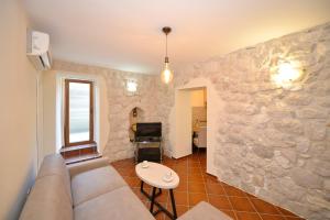 a living room with a couch and a stone wall at Kuzman Apartments in Kotor