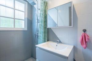 a white bathroom with a sink and a mirror at Villa Nicole face mer in Trégunc +24 photos