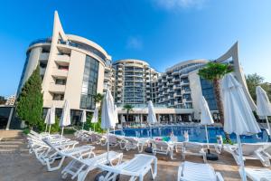a resort with a pool and lounge chairs and umbrellas at Hotel Zenith in Sunny Beach