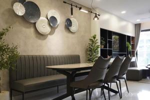 a dining room with a table and chairs and plates on the wall at Nhà của Hải - Apartment Luxury Diamond Brilliant in Ho Chi Minh City +25 photos