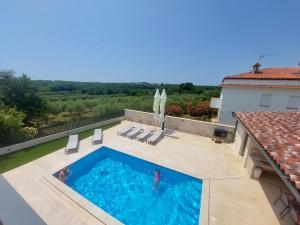 a person swimming in a swimming pool on top of a house at Villas Salvore & Faro - Perfect combination of nature, sea and comfort, heated pool, games room, Savudrija - Istria in Savudrija