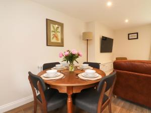 a dining room with a table with chairs and flowers on it at Heron View in Preston