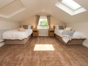 a attic bedroom with two beds and a window at Heron View in Preston