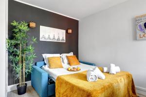 a bedroom with a blue couch and a bed with a table at 866 Suite Lilas - Superbe appartement in Montreuil