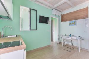a kitchen with a sink and a table with chairs at Residenza Rio Marina de luxe in Rio Marina +65 photos