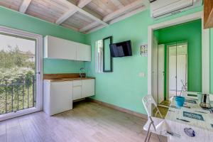 a kitchen with green walls and a table and chairs at Residenza Rio Marina de luxe in Rio Marina