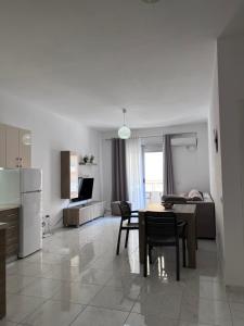 Una cocina y una sala de estar con mesa y sillas. en Alis Apartment, en Orikum