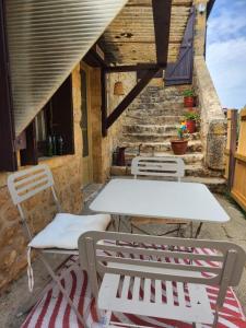 a table and chairs on a patio with stairs at Corps de ferme rénové à 10 min de Sarlat in Carsac-Aillac