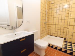 a bathroom with a sink and a toilet and a mirror at Winahost Casa a Sant Feliu de Guíxols in Sant Feliu de Guixols