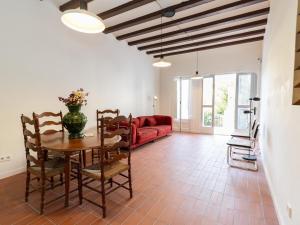 a living room with a table and a red couch at Winahost Casa a Sant Feliu de Guíxols in Sant Feliu de Guixols