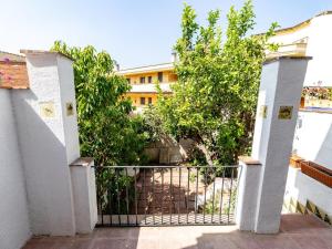 an open gate with trees and a building in the background at Winahost Casa a Sant Feliu de Guíxols in Sant Feliu de Guixols
