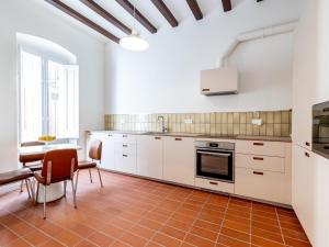 a kitchen with white cabinets and a table and chairs at Winahost Casa a Sant Feliu de Guíxols in Sant Feliu de Guixols +15 photos