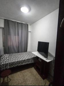 Cette petite chambre comprend un lit et une télévision. dans l'établissement Habitación cama grande doble 150 x190 TV wifi, à Alicante