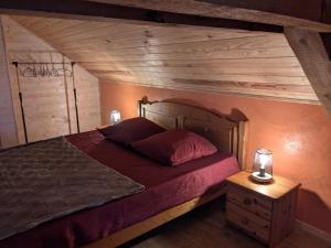 a bedroom with a large bed and a wooden ceiling at La Grange in Le Noyer