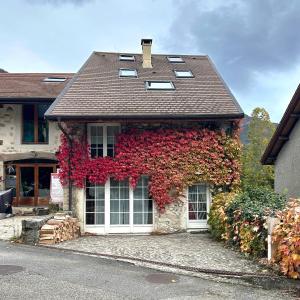 a house with red ivy on the side of it at Charming village house in Chevrier France, near Geneva in Chevrier