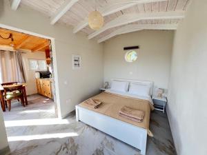 a bedroom with a large bed and a table at Linda House Corfu in Gastouri