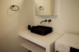 a bathroom with a black sink on a white counter at Faragnanti #2 in Gythio +17 photos
