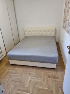 una cama en una habitación con suelo de madera en Nika-Simka, en Banja Luka