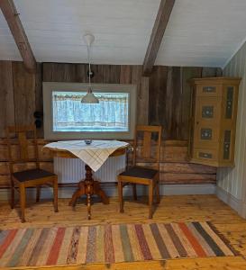 a dining room with a table and two chairs and a window at Brygghuset in Skillingaryd