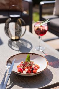 a plate of food and a glass of wine on a table at Hotel Club Le Capet in Sainte-Maxime +18 photos