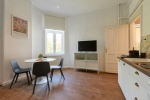 a kitchen with a table and chairs and a tv at #Hidden Central Nest with AC & Terrace in Timişoara