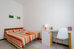Un dormitorio con una cama, un escritorio y una silla. en A pochi passi dal mare Appartamento in centro, en Lido di Jesolo