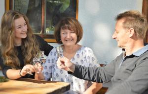a man and woman sitting at a table with wine glasses at Pension Steinerhof in Oberau