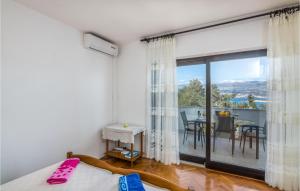 a bedroom with a bed and a balcony with a table at Nice Apartment In Silo With Wifi in Šilo