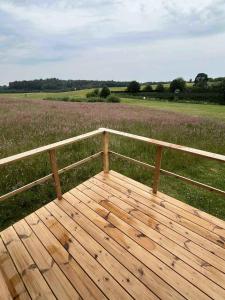 a wooden deck with a view of a field at Lake Cabin In Peaceful Natural Surroundings in Østbirk
