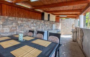 a patio with a table and chairs and a stone wall at Beautiful Apartment In Bribir With Wifi in Bribir +19 photos