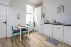 a kitchen with white cabinets and a table and chairs at Glenmore Lodge in Belfast