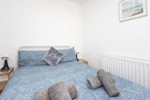 a bedroom with a blue bed with pillows on it at Glenmore Lodge in Belfast